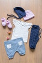 Set of clothes and items for the child on a wooden background to choose from: T-shirt, pants, caps, socks, dummies Royalty Free Stock Photo