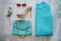Set of clothes on the white background. Turquoise bag, sweater, beige high hills shoes, sunglasses Royalty Free Stock Photo