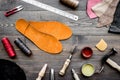 Set of cobbler tools on brown wooden desk background top view