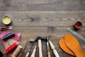 Set of cobbler tools on brown wooden desk background top view copyspace