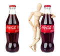 Set of Coca-Cola soft drink bottle and wooden manikin embrace it, isolated on white background. Coca-Cola, or Coke, is a