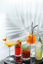 Set cocktails on marble table and light background. five kinds of colorful summer cocktails in glasses and shadow of tropic leaf Royalty Free Stock Photo