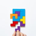 Set of color blocks puzzle pieces and hand holding last one piece on white background Royalty Free Stock Photo