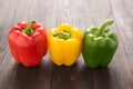 Set of colored bell peppers on wooden background