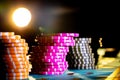 Set of colored chips for gambling in casino on a black background. Yellow and pink gaming chips on poker table in the