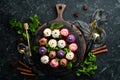 Set of colored cream muffins on a black plate with mint. Top view. Rustic style