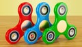 Set of colored fidget spinners on the wooden table. 3D rendering
