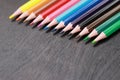 A set of colored pencils on a black wooden background. Sharpened bright pencils Royalty Free Stock Photo