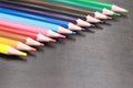 A set of colored pencils on a black wooden background. Sharpened bright pencils Royalty Free Stock Photo