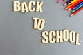 A set of colored pencils on gray background from above. Inscription from wooden letters: back to school. Flat lay, copy Royalty Free Stock Photo