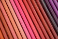 A set of Colored pencils lying in a beautiful gradient transition from yellow to pink and red, brown and purple hues. Abstract