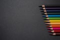 Set of colored pencils, row of wooden colored pencils on black background, colored pencils for drawing, colorful, copy space. Royalty Free Stock Photo