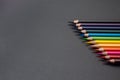 Set of colored pencils, row of wooden colored pencils on black background, colored pencils for drawing, colorful, copy space. Royalty Free Stock Photo