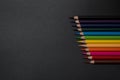 Set of colored pencils, row of wooden colored pencils on black background, colored pencils for drawing, colorful, copy space. Royalty Free Stock Photo