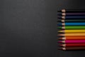 Set of colored pencils, row of wooden colored pencils on black background, colored pencils for drawing, colorful, copy space. Royalty Free Stock Photo