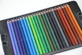 A set of colored pencils in a black stand on a white background. Materials, tools for drawing, creativity, hobbies