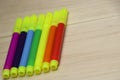 Set of colored pens on wooden background