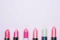 Set of colored pink lipsticks on pink background. Women`s cosmetics. Selective focus. Copy space Royalty Free Stock Photo
