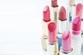 Set of colored pink lipsticks on white background. Women`s cosmetics. Selective focus. Copy space Royalty Free Stock Photo