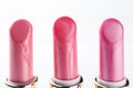 Set of colored pink lipsticks on white background. Women`s cosmetics. Selective focus. Copy space Royalty Free Stock Photo