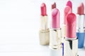 Set of colored pink lipsticks on white background. Women`s cosmetics. Selective focus. Copy space Royalty Free Stock Photo