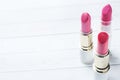 Set of colored pink lipsticks on white background. Women`s cosmetics. Selective focus. Copy space Royalty Free Stock Photo