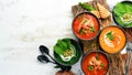 Set of colored tasty soups on white wooden background. Spinach, tomato and carrot soup. Royalty Free Stock Photo