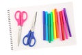 Set of colorful felt tip pens and two scissors on a blank, opened sketchbook sheet, isolated on white background. Art and creativi