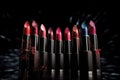 Set of colorful lipsticks with splash on black background Royalty Free Stock Photo