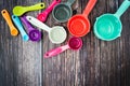 Set of colorful measuring cups and measuring spoons use in cooking lay on dark brown wood tabletop Royalty Free Stock Photo