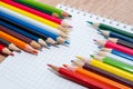 Set of colorful pencils lying in row on white paper Royalty Free Stock Photo