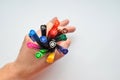 Set of colorful pens holding in man`s hand like sign OK, top view on black background Royalty Free Stock Photo