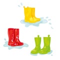 Set of colorful rubber boots in puddle of water