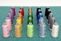 A set of colorful spools of thread on green cutting mat