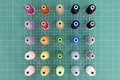 A set of colorful spools of thread on green cutting mat