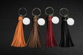 A set of Colorful Tassel key ring on black wooden background. Fashion leather key chain for decoration Royalty Free Stock Photo