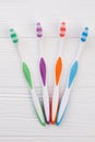 Set of colorful tooth brushes on white wooden background. Royalty Free Stock Photo