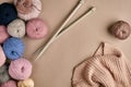 Set of colorful wool yarn and knitting on knitting needles on beige background. Top view Royalty Free Stock Photo