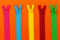 Set of colorful zipper on orange paper background.