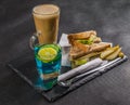 set consisting of two sandwiches malted bread with vintage cheddar cheese, pickles, red onion, tomato, lettuce, blue drink and co Royalty Free Stock Photo