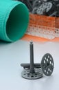 A set of construction items for the insulation of walls. Plastic dowels, a roll of mesh for the insulation of facades and a corne Royalty Free Stock Photo