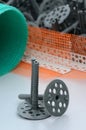 A set of construction items for the insulation of walls. Plastic dowels, a roll of mesh for the insulation of facades and a corne Royalty Free Stock Photo