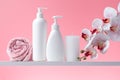 Set of cosmetic bottles, towel, orchid and candle in bathroom. White flacon, soap dispenser and other toiletries for personal