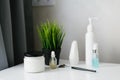 Set of cosmetic jars and a green potted plant on the bathroom table Royalty Free Stock Photo