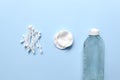 Set of cosmetic products on blue color background. Cotton pads, cotton sticks, bottle, makeup remover, micellar water, wash gel. Royalty Free Stock Photo