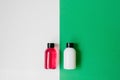 Set of cosmetic products for shower or bath, white and pink bottles on white and green background. Royalty Free Stock Photo