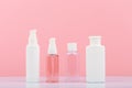 Set of cosmetic products for skin cleaning, exfoliating and moisturizing. Cosmetic bottles against pink background Royalty Free Stock Photo