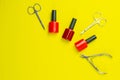 A set of cosmetic tools for manicure and pedicure. Manicure scissors, cuticles, saws, miller stand on a yallow background. Top