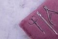 A set of cosmetic tools for manicure and pedicure stand on a pink fluffy notebook for recording clients. tweezers, scissors and