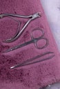 A set of cosmetic tools for manicure and pedicure stand on a pink fluffy notebook for recording clients. tweezers, scissors and